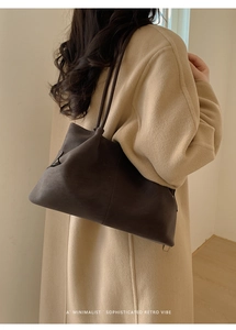 Close-up of minimalist retro tote bag in dark coffee suede worn with a wool coat