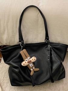 Borsa tote nera minimalista in ecopelle con dettagli argentati e ciondolo di peluche