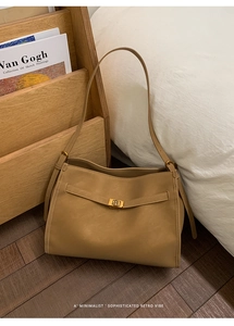 Macro shot of the camel faux leather texture and golden metal twist lock on the bag