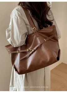 Side detail of retro brown tote bag with adjustable metal buckle on textured leather