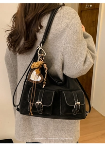Detail van zwarte shopper met contraststiksels en twee klepzakken aan de voorkant