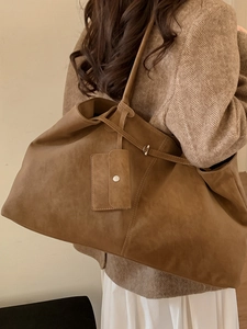 Grand sac cabas marron en daim avec pochette amovible porté par un mannequin en manteau