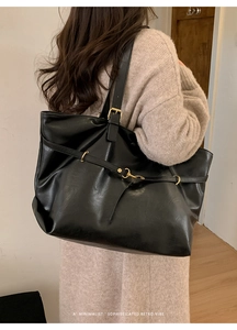 Close-up of black retro leather tote bag featuring natural texture and metal buckle detail