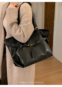 Detail of matte black retro tote bag showing fine texture and golden metal hardware buckles