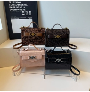 Détail de quatre petits sacs carrés avec imprimé léopard et texture crocodile et cœur