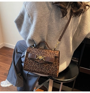 Dettaglio della borsa leopardata con fibbia a cuore dorata e tracolla in pelle sul modello