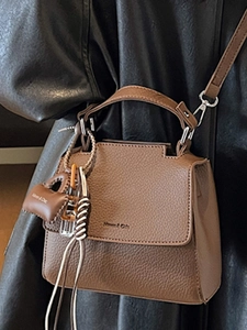 Brown leather trapezoid handbag with top handle and detachable shoulder strap in dark tone