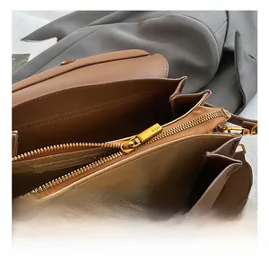 Vue détaillée de l'intérieur du sac marron avec zip doré et bandoulière tissée