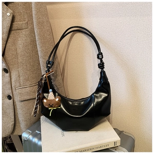 Detail der schwarzen Hobo-Tasche mit braunem Bärenanhänger und verstellbarem Knotengurt