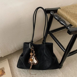 Detail of black suede tote bag with heart leopard print charm and long shoulder straps