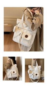 Détail d'un grand sac fourre-tout en nylon blanc cassé avec poches et petit porte-monnaie rond