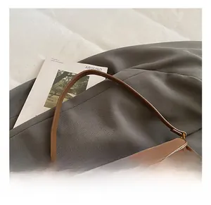 Détail d'un sac vintage en cuir marron avec boucle en métal doré et bandoulière réglable