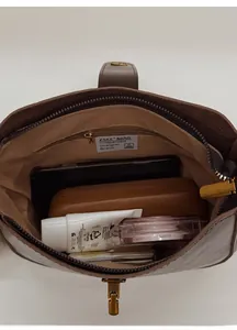 Internal view of the brown leather bucket bag showing storage space and zipper pocket