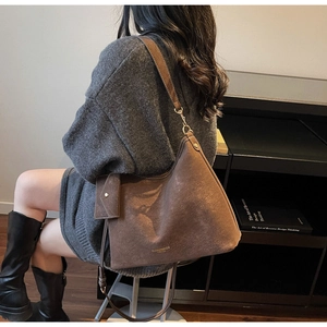 Sac fourre-tout en daim marron avec porte-monnaie amovible dans un décor de bureau