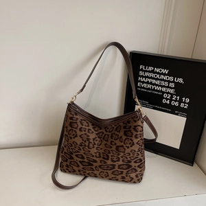Vue détaillée du sac cabas léopard avec anses en cuir marron et boucle dorée