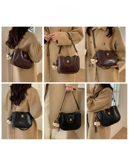 Detail view of retro PU leather bucket bags with gold twist locks and plush bear charms