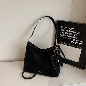 Détail d'un sac cabas en daim noir avec bandoulière amovible et pochette à monnaie suspendue