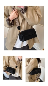 Vue détaillée du sac bandoulière en cuir noir avec sa sangle en tissu pied-de-poule