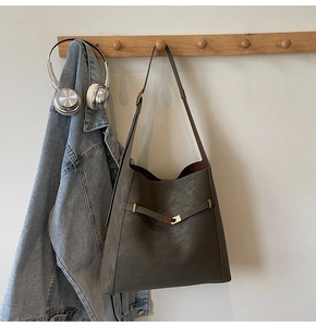 Detail of matte dark brown faux leather bucket bag with metallic ring strap on hanger