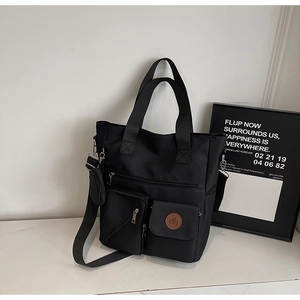 Vue détaillée du grand sac cabas noir en nylon avec poches multiples et petit porte-monnaie