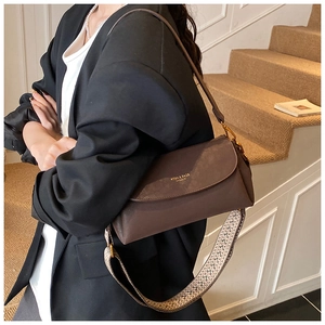 Détail d'un sac à main vintage en cuir marron avec logo doré et deux bandoulières chic