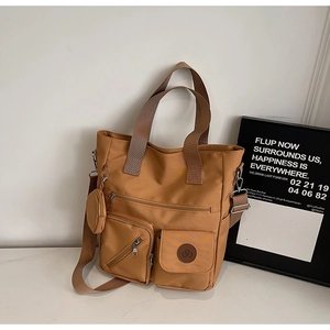 Détail d'un sac cabas kaki avec poches zippées et petit porte-monnaie rond amovible