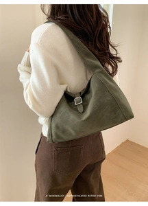 Detail of dark green suede hobo bag with silver buckle and minimalist retro texture