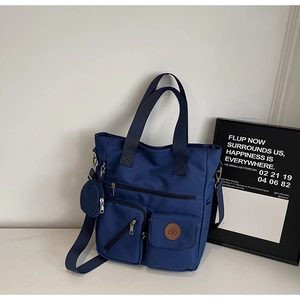 Détail du sac cabas bleu marine multi-poches avec petit porte-monnaie et bandoulière