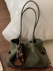 Vintage dark green oversized leather tote bag with minimalist shoulder straps and charms
