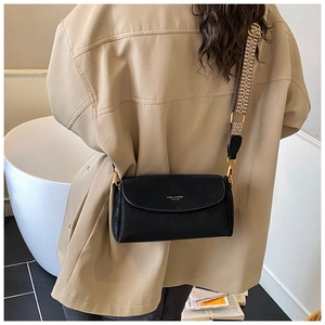 Détail d'un sac bandoulière vintage noir avec sangle géométrique et logo doré élégant