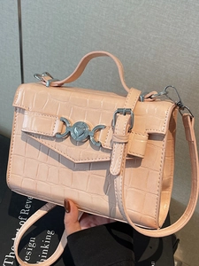 Borsa a mano rosa con goffratura coccodrillo e fibbia a cuore in posa da studio