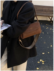 Détail du sac à bandoulière rétro en cuir marron avec sangle large à motif géométrique