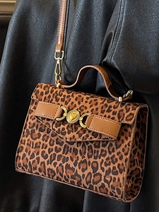 Borsa a tracolla leopardata minimalista con fibbia a cuore dorata su cappotto grigio