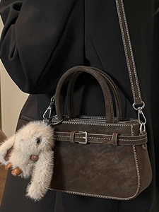 Retro brown suede handbag with white stitching and plush rabbit charm detail