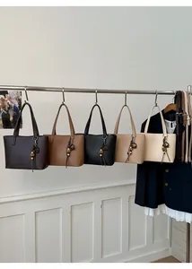 Close-up of minimalist leather bucket bags in coffee, black and beige colors