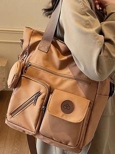 Sac fourre-tout marron en nylon avec plusieurs poches et porte-monnaie en vue latérale