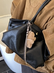 French vintage black leather tote bag with a cute plush bear charm for daily commuting