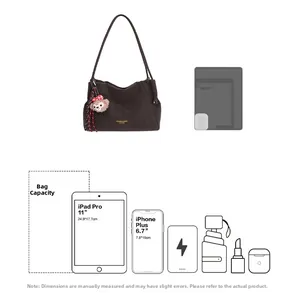 Détail d'un grand sac fourre-tout avec lettrage doré et charmant pendentif en peluche