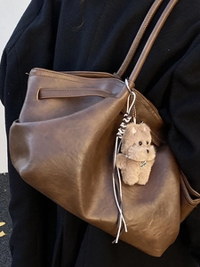 French vintage brown leather tote bag with plush dog charm and shoulder strap
