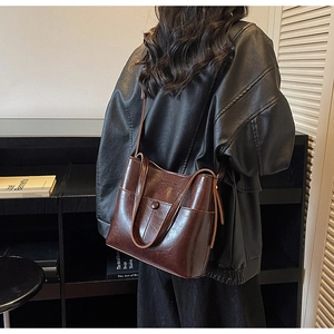 Détail d'un sac à bandoulière vintage en cuir huilé marron avec un grand compartiment