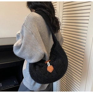 Detail of black fuzzy crescent tote with wooden horn button and leather patch