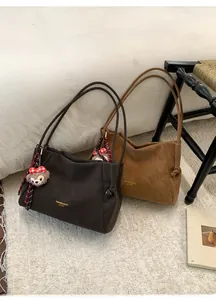 Détails des sacs cabas en daim marron et caramel avec breloques d'ours et écharpe