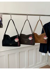 Gros plan de grands sacs cabas minimalistes au fini mat avec breloques d'ours en peluche