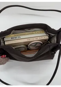 Vue de dessus de l'intérieur spacieux du sac cabas marron foncé avec livres et cosmétiques