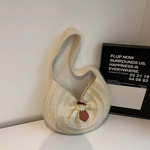 Detail of off-white knit hobo bag with unique woven texture and dark brown horn button