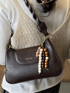 Deep brown PU leather shoulder bag with twisted strap and beaded charm pendant for women