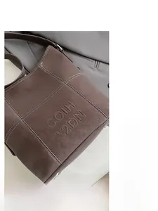 Dettaglio della borsa tote marrone vintage con logo goffrato e cuciture a contrasto
