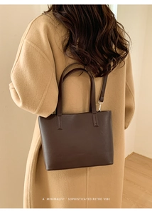 Borsa a secchiello in pelle marrone scuro dal design retrò abbinata a cappotto lungo