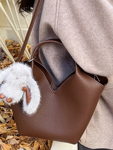 Sac seau vintage en cuir marron foncé avec charm lapin en peluche et ouverture en forme de V