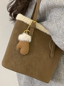 Brown suede underarm bucket bag with white faux fur trim and glove charm accessory
